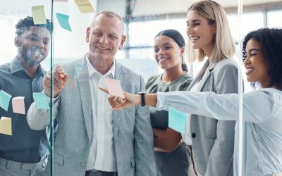 Business people planning on sticky note in meeting, post it paper for creative advertising idea and team collaboration for marketing project. Teamwork for global company strategy on glass in office